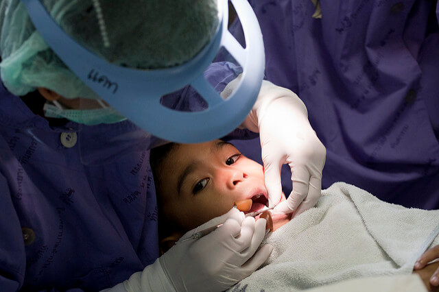 Dentist is checking a boy's teeth