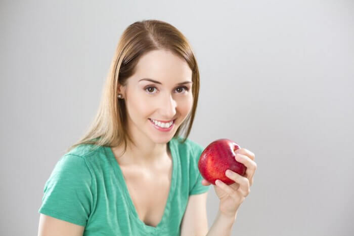 Young woman eating fruit