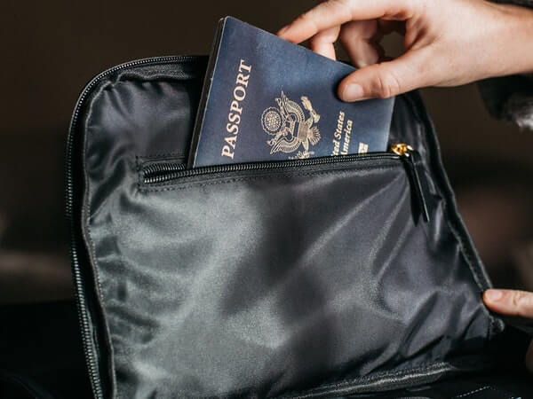 Person putting a passport on bag