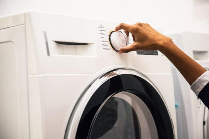 Woman adjusting control on front load washer